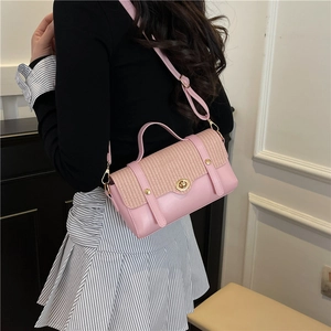 Pink minimalist crossbody bag with woven flap and gold twist lock shown on a model