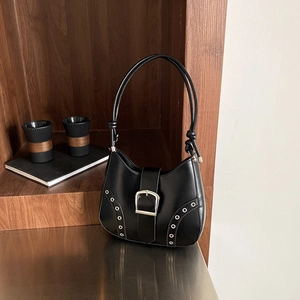 Minimalist black leather hobo bag with large silver buckle and grommet detailing
