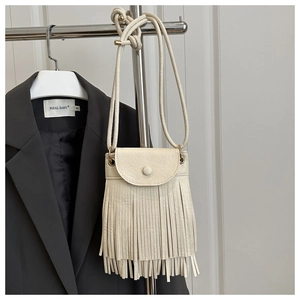 Détail du sac bandoulière crème à franges avec doubles pompons et texture en cuir PU