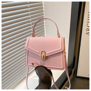 Detail van roze kunstlederen crossbodytas met gouden gesp en een verstelbare schouderriem