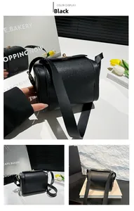Detail of black lychee grain leather crossbody bag with golden square twist lock hardware