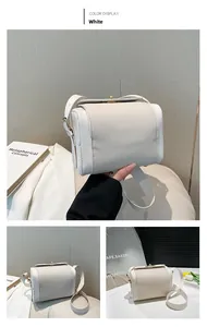 Detail of cream leather shoulder bag showing pebbled texture and gold twist lock closure