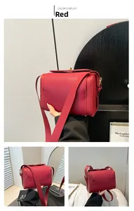 Detail view of red lychee pattern leather bag with gold metal buckle and wide strap