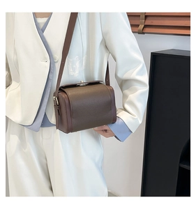 Detail of vintage box crossbody bag showing lychee leather texture and metal clasp