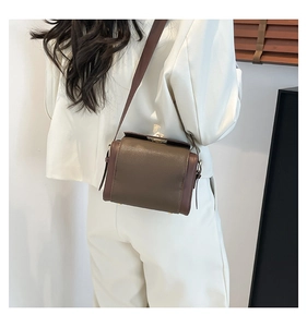 Detail of retro leather crossbody bag in caramel and coffee tones with lychee texture