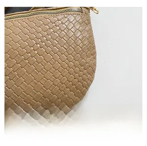 Close-up of beige woven leather texture and premium gold zipper hardware details