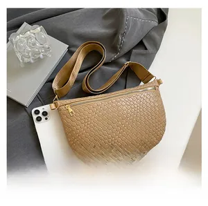 Detailed macro view of khaki woven PU leather texture and gold zipper on a saddle bag