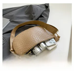 Interior view of beige woven crescent bag showing space for phone and makeup