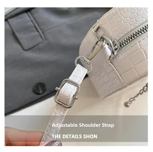 Close-up of white crocodile pattern bag featuring adjustable silver buckle and neat stitching