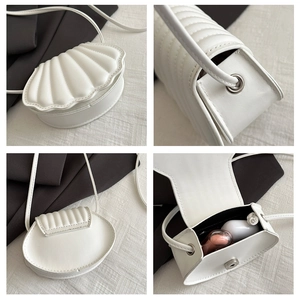 Interior view of white shell bag showing capacity for lipstick and wireless earphones