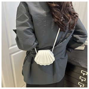 Detailed back view of a white shell-shaped crossbody bag with radial quilted leather pattern
