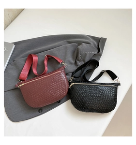 Detailed close-up of woven texture on burgundy and black crossbody bags with gold zippers