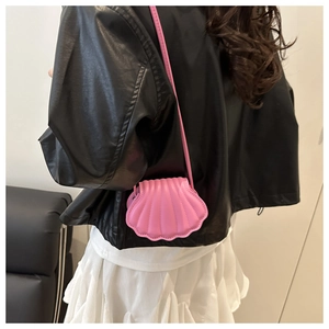 Close-up of a pink shell-shaped crossbody bag featuring textured 3D radial ridges