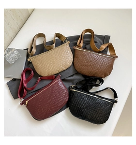 Détail de sacs bandoulière tressés en coloris beige, marron, bordeaux et noir classique