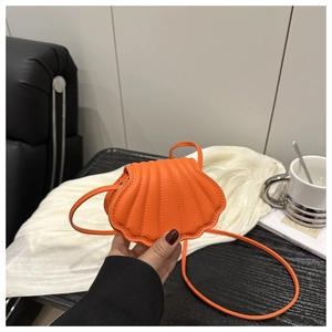 Detailed view of mini orange shell bag in PU leather with stylish textured stitching