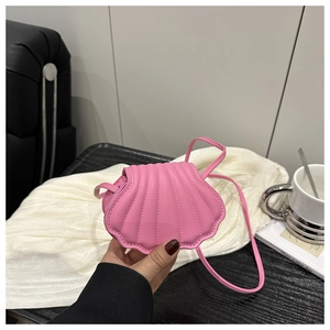 Close-up of pink shell-shaped crossbody bag featuring textured matte faux leather finish