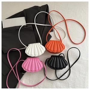 Flat lay of four seashell-shaped crossbody bags in white, pink, black and orange colors