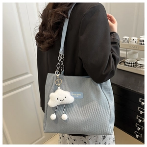 Détail du sac cabas bleu montrant la texture sergée et le joli pendentif nuage