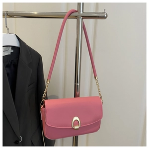Détail du sac bandoulière rose avec boucle fer à cheval dorée et élégante chaîne métal