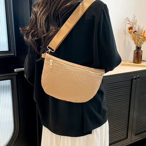 Sac bandoulière beige tissé avec large sangle d'épaule et design élégant en demi-lune