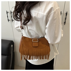 Détail du sac besace en daim marron avec franges vintage et boucle métallique