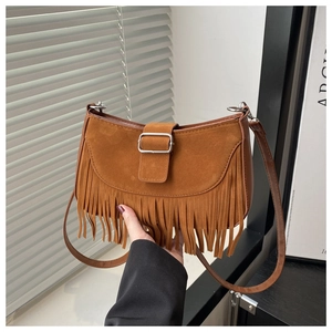 Nahaufnahme der braunen Wildledertasche mit Silberschnalle und langen Fransenanhängern