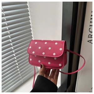 Detailed view of pink polka dot crossbody bag with matching slim shoulder strap