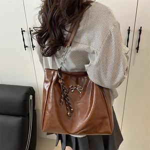 Retro brown large capacity tote bag in glossy leather with stylish metal bow accent