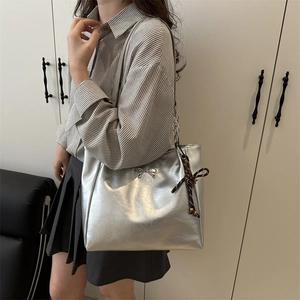 Silver large tote bag with metal bow and silk scarf detail for stylish daily commuting
