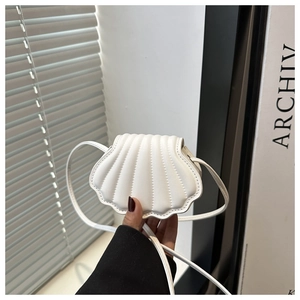 Detailed close-up of quilted white shell bag showing elegant fanned fold leather texture