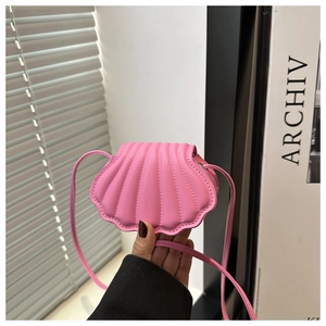 Detailed close-up of a pink shell-shaped crossbody bag with trendy embossed pattern