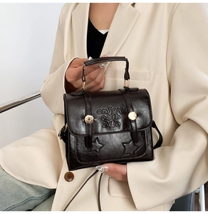 Detailed view of dark brown faux leather bag with vintage star embossing and metal buckles