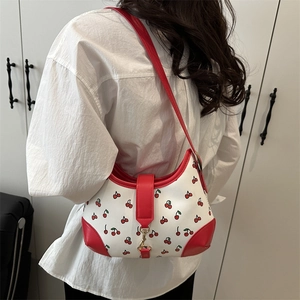 Retro crescent underarm bag with red cherry print and golden buckle on model