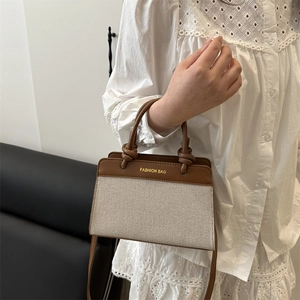 Brown leather and beige canvas vintage tote bag featuring gold fashion bag lettering