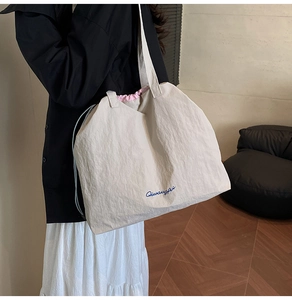 Λεπτομέρεια μεγάλης πάνινης τσάντας με ροζ εσωτερικό κορδόνι και μπλε κέντημα