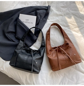 Close-up of matte PU leather shoulder bags with bow details and heart metal studs