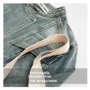Detail of blue denim fabric texture and sturdy woven canvas shoulder strap on the bag