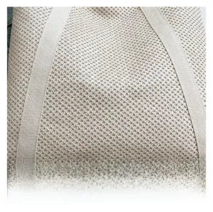 Detailed macro view of beige woven texture and thick webbing handles on summer straw bag