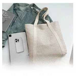 Detail showing beige woven texture of a large tote bag alongside an iPad and casual items