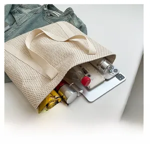 Detail showing high-capacity interior of a beige woven tote bag with daily essentials
