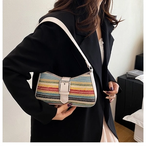 Close-up of rainbow woven baguette bag with cream leather strap and gold buckle