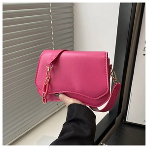 Detail of hot pink crossbody bag with thick resin chain and textured faux leather