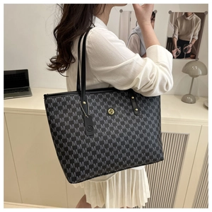 Detail of monogram jacquard tote bag with leather strap and metallic M logo detail