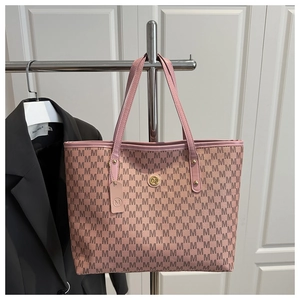 Detailed close-up of pink tote bag with M-letter print and gold metal logo emblem