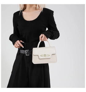 Detail shot of vintage beige square handbag featuring gold twist lock and sturdy handle