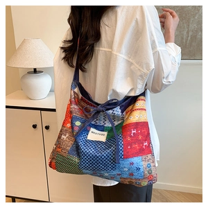 Detail of bohemian patchwork tote bag with colorful geometric patterns and ribbon bow