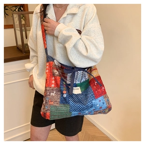 Detail of colorful patchwork tote bag with ethnic elk pattern and decorative bow knot