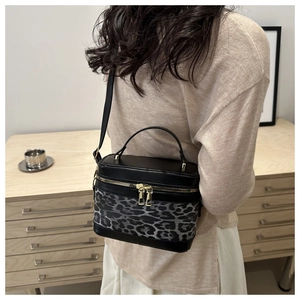 Details der Zylinder-Tasche mit Leopardenmuster, Goldreißverschluss und Ledertextur