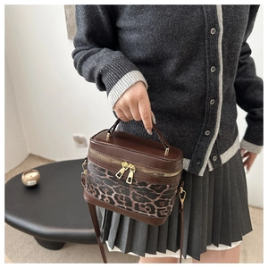Détails du sac seau léopard avec garniture en cuir marron et double fermeture éclair dorée