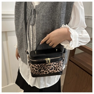 Vue détaillée du sac boîte léopard avec ferrures dorées et bandoulière noire femme